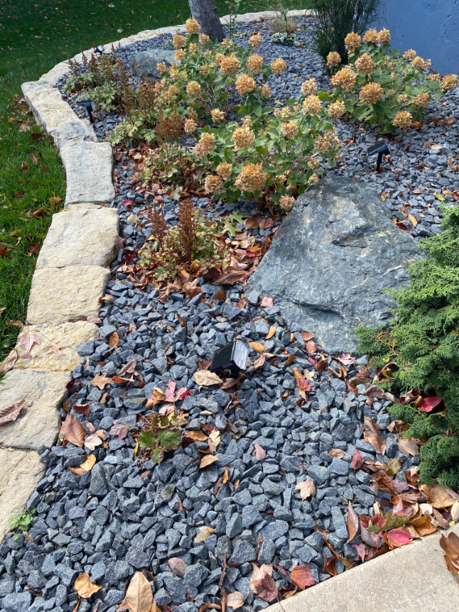 Black Granite landscaping gravel in a planter bed with limestone edging located in Kansas City