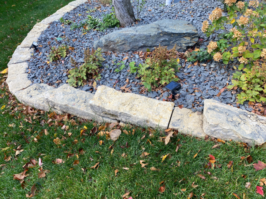 Black Granite landscaping gravel in a planter bed with limestone edging located in Kansas City