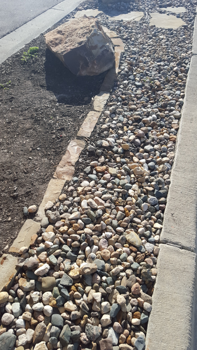 Missouri Rainbow River Rock used in a landscape bed with stone edging located in Kansas City