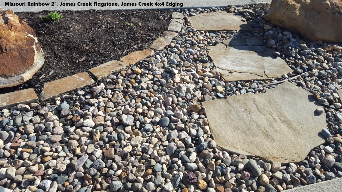 Missouri Rainbow River Rock used in a landscape bed with flagstone stepping stones located in Kansas City