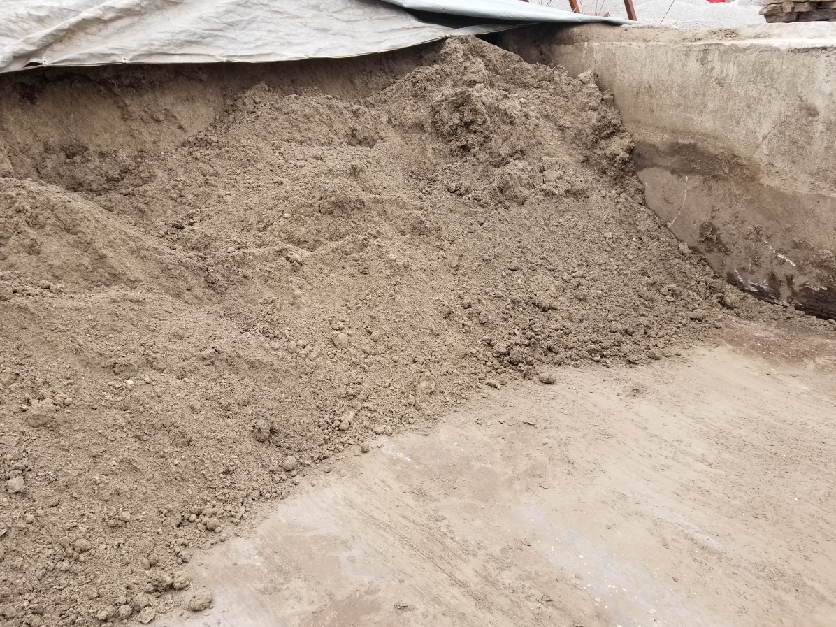 A large bin of top soil in a yard located in Kansas City