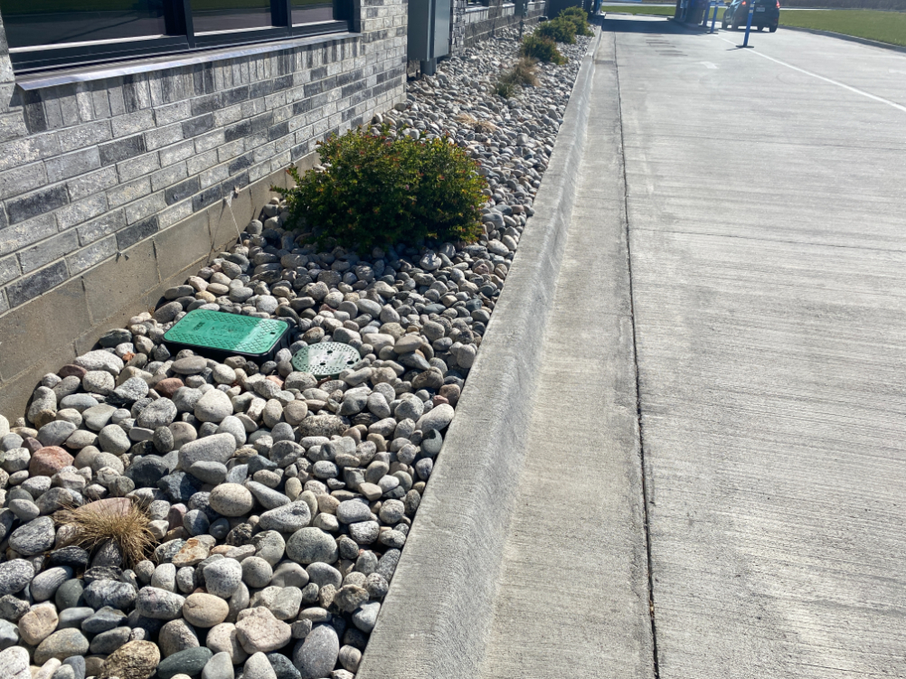 Gray Cobblestone next in a landscape bed next to a street