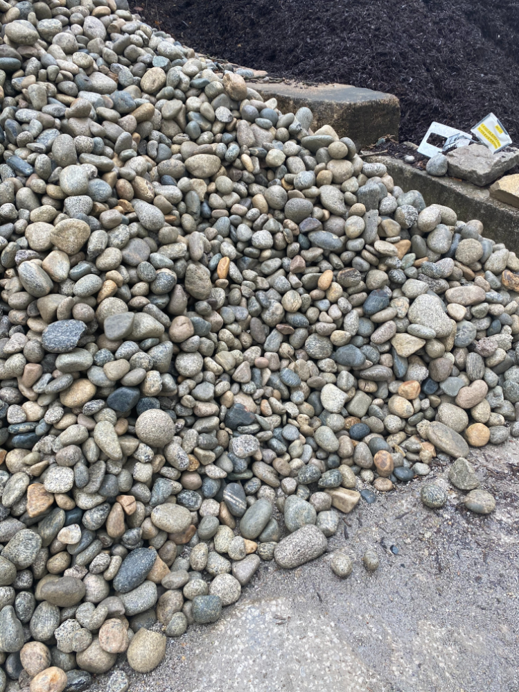 A large pile of Gray Cobblestones that are wet