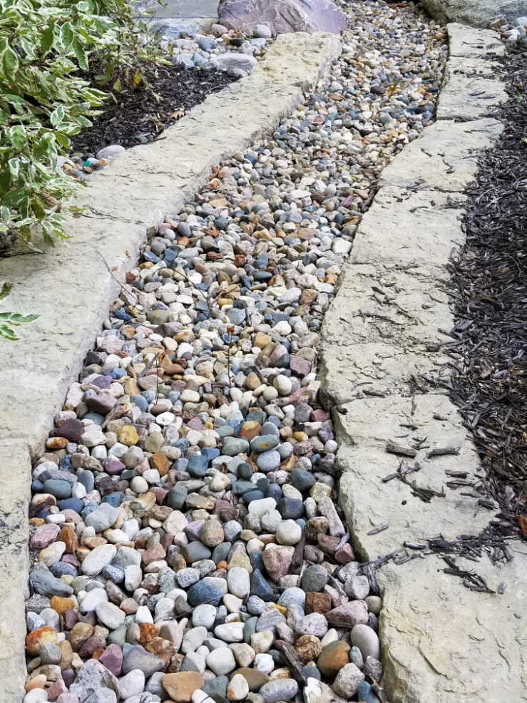Missouri Rainbow River Rock used in a landscape bed located in Kansas City